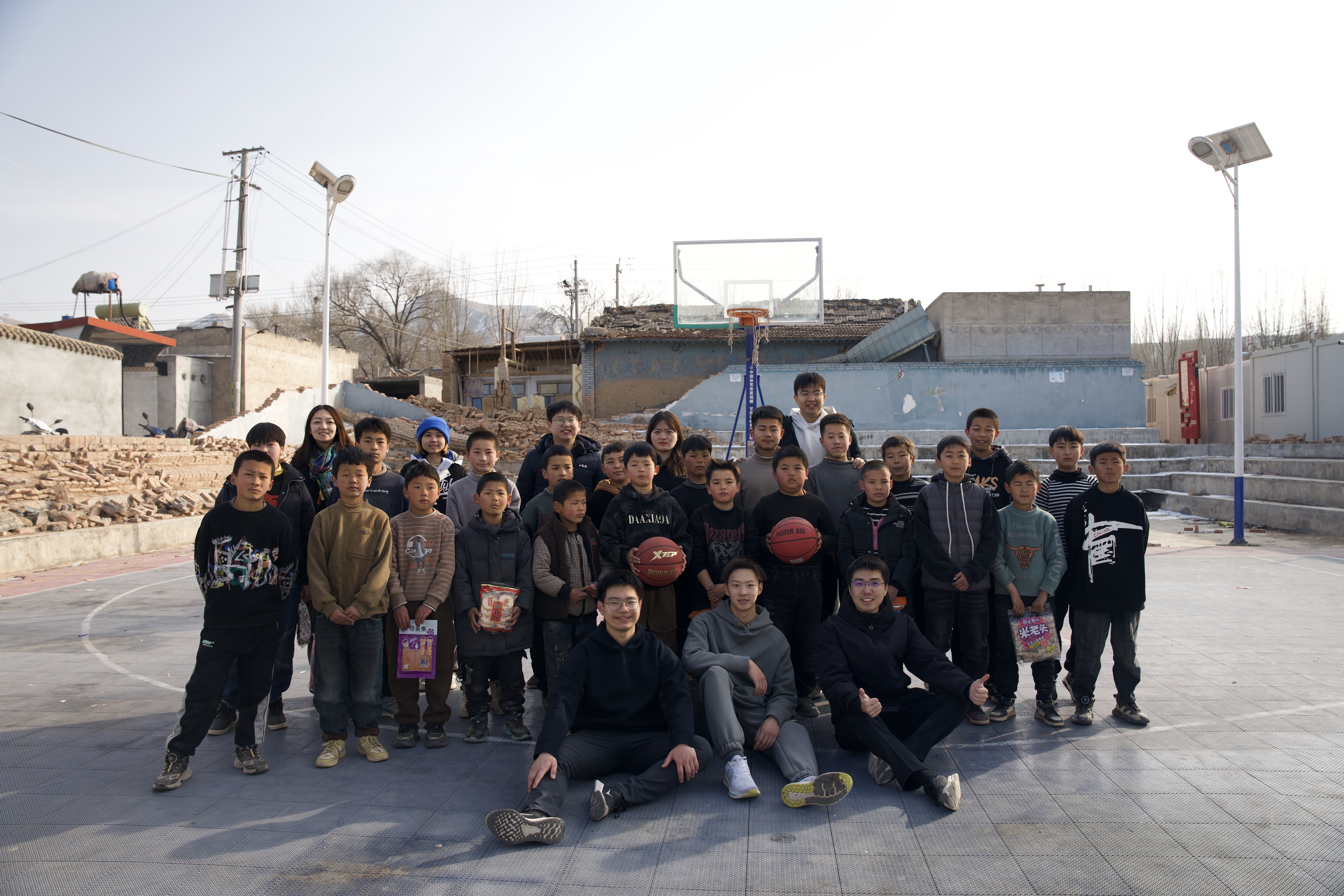 20240219-学思践悟挺膺行,青春建功新时代——2024年火博在线研究生寒假社会实践纪实(一)-“社稷担当·心泽河州”实践支队-支队成员在在震区球场组织开展“青少年村BA”篮球赛.jpg